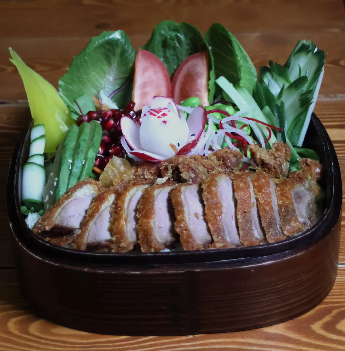 Knusprige Ente auf Reis mit frischem Gemüse und Sesam in einer Bowl