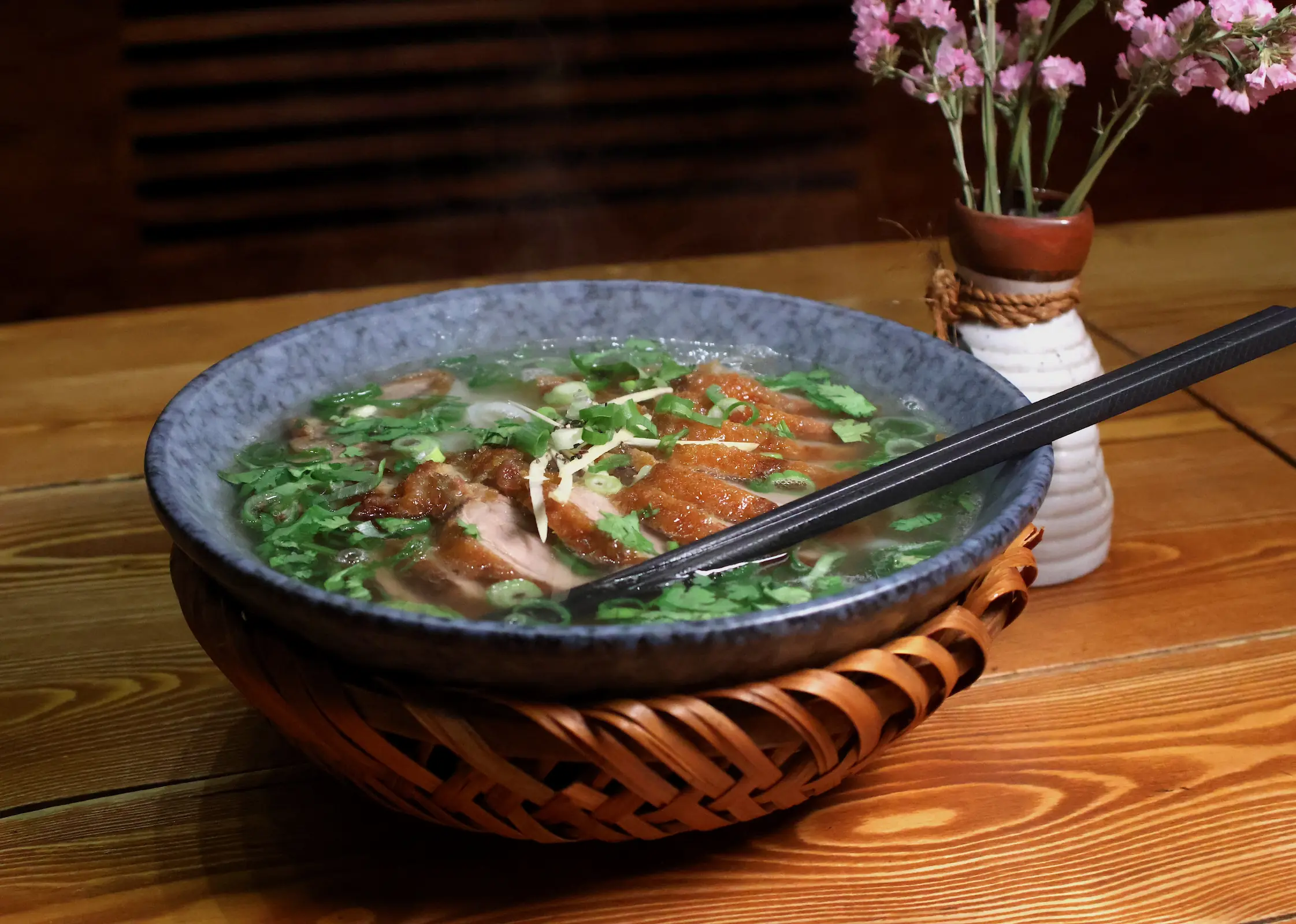 Vietnamesische Phở Reisnudelsuppe serviert mit knuspriger Ente und Kräutern